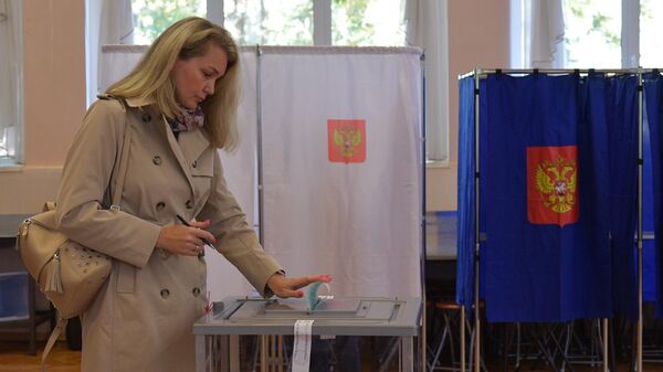 Женщина голосует на выборах