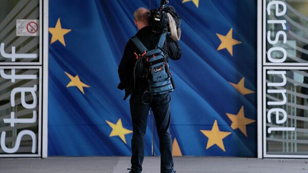 Представитель СМИ возле здания Европейской комиссии в Брюсселе