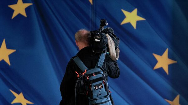 Представитель СМИ возле здания Европейской комиссии в Брюсселе