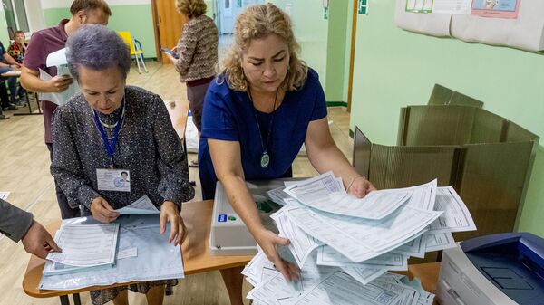 Сотрудники избирательной комиссии во Владивостоке подсчитывают бюллетени после завершения голосования