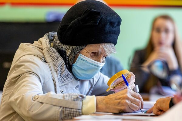 Женщина регистрируется на избирательном участке №915 во Владивостоке для участия в голосовании на выборах депутатов городской Думы
