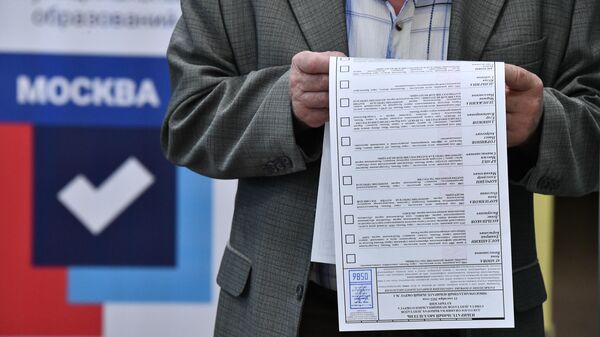 Житель Москвы изучает бюллетень на избирательном участке № 586