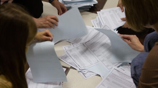 Сотрудники избирательного участка в Томске подсчитывают бюллетени после завершения голосования на досрочных выборах губернатора области