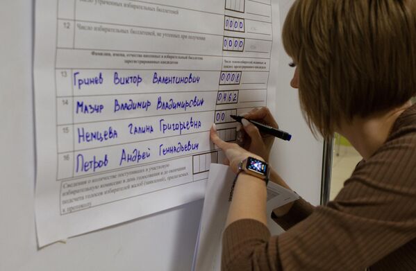 Сотрудница избирательного участка в Томске вносит данные по бюллетеням после завершения голосования на досрочных выборах губернатора области
