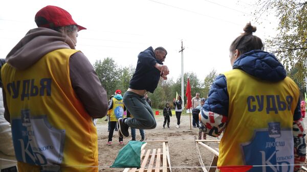 Участник XXV традиционных Саамских национальных игр прыгает через сани в поселке станции Лопарская Мурманской области