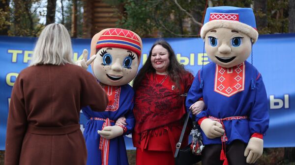 Девушка фотографируется с маскотами XXV традиционных Саамских национальных игр в поселке станции Лопарская Мурманской области