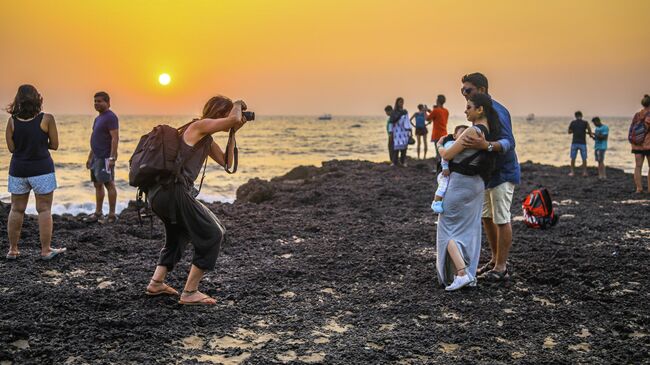 Туристы фотографируются на пляже в Гоа