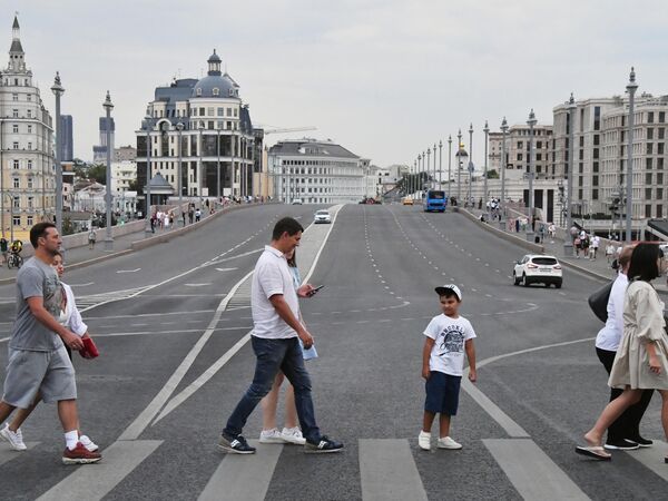 Прохожие идут по пешеходному переходу перед Большим Москворецким мостом Прохожие идут по пешеходному переходу перед Большим Москворецким мостом
