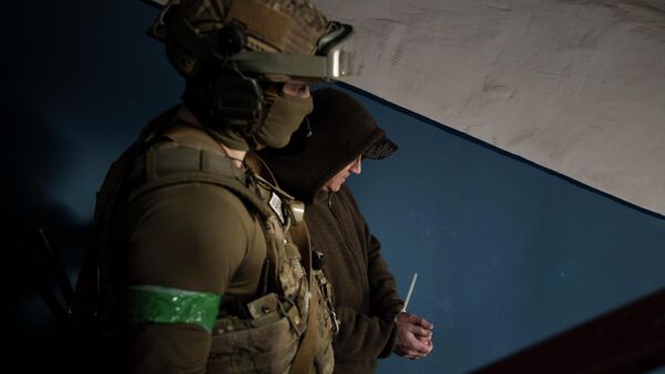 Сотрудник Службы безопасности Украины задерживает мужчину во время рейда в Харькове, Украина