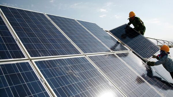 Рабочие устанавливают солнечные батареи на электростанции в Китае
