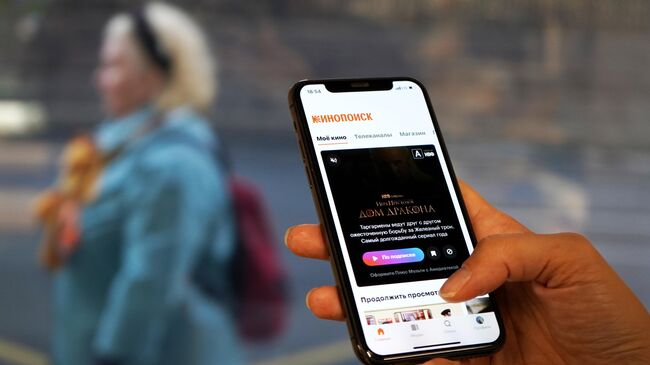Смартфон с изображение сервиса Кинопоиск