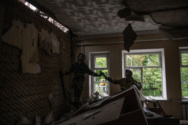 Сотрудники пожарной МЧС ЛНР в одной из аудиторий здания ГОУ СПО Перевальский колледж, частично разрушенного в результате обстрела ВСУ города Перевальск