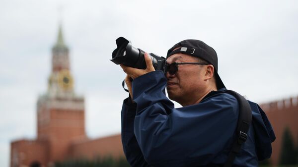 Мужчина фотографирует достопримечательности на Красной площади в Москве