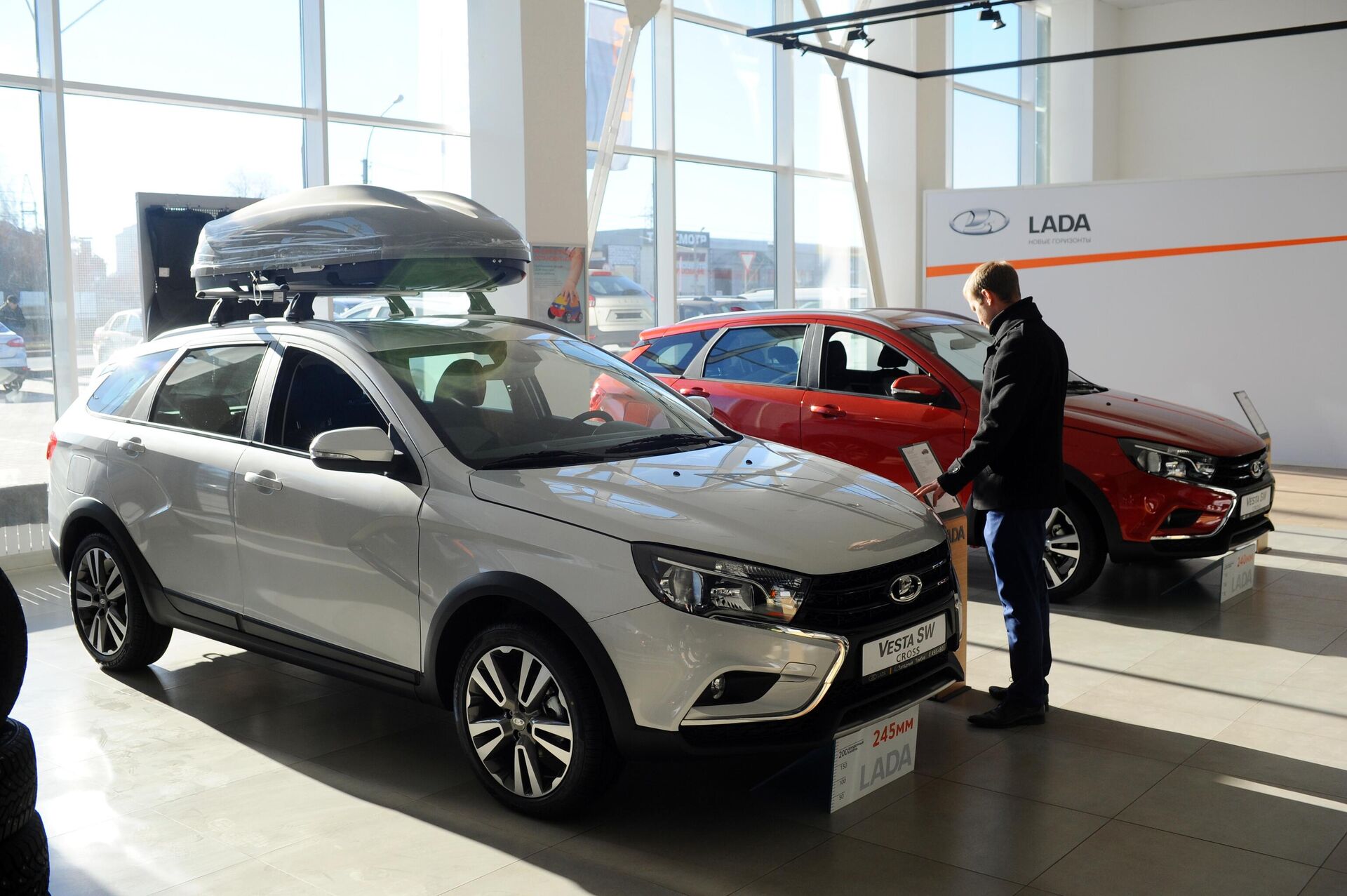 Посетитель рассматривает автомобиль Lada Vesta SW в демонстрационном зале автоцентра Западный в Тамбове - РИА Новости, 1920, 16.09.2022