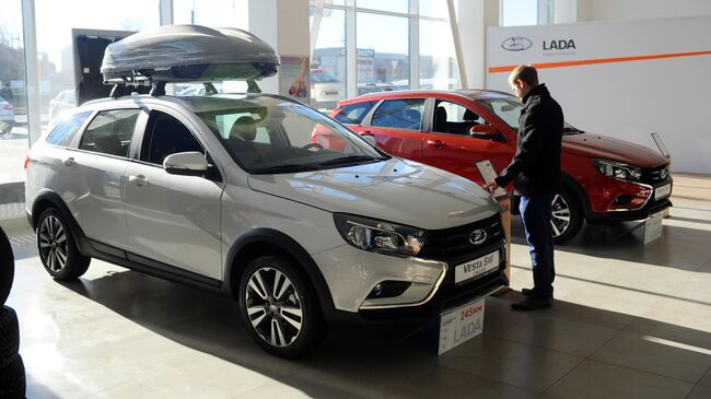 Посетитель рассматривает автомобиль Lada Vesta SW