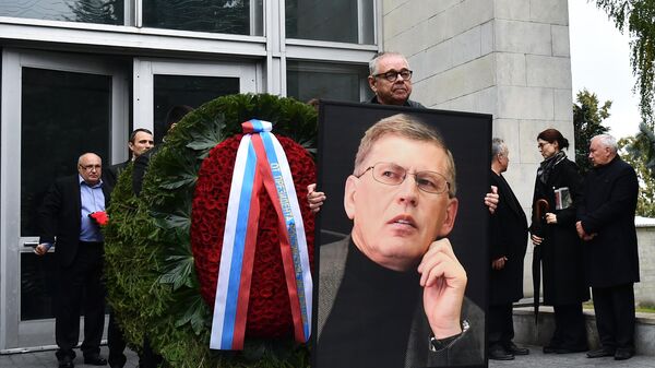 Портрет Владимира Сунгоркина выносят вместе с венками из похоронного дома Троекурово после церемонии прощания