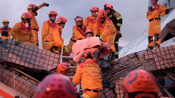 Спасатели эвакуируют пострадавшего при землетрясении в округе Хуалянь, Тайвань
