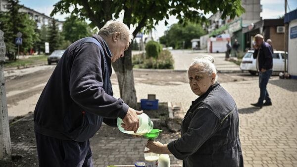 Жительница Соледара покупает молоко на улице города