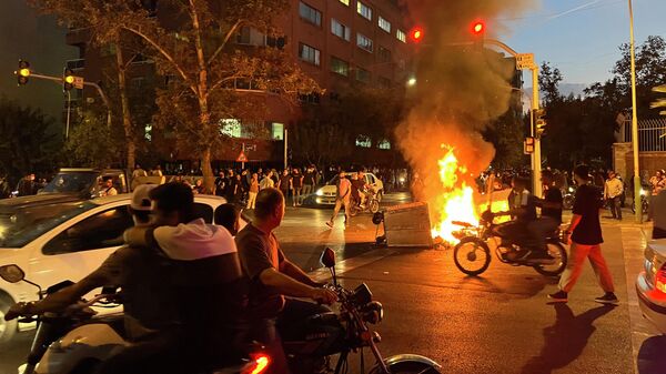 Горящие баррикады во время акции протеста в Тегеране