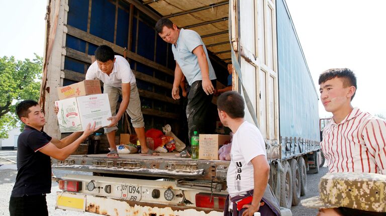 Разгрузка гуманитарной помощи для беженцев в селе Боз-Адыр в Киргизии