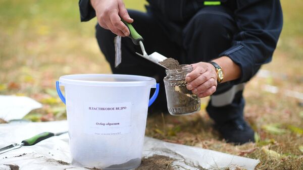 Специалист Мосэкомониторинга берет образец почвы в Москве