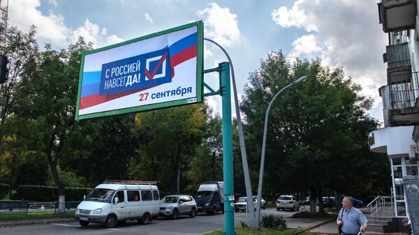 Плакат С Россией навсегда в рамках подготовки к референдуму о присоединении к России ЛНР на улице Луганска