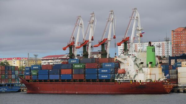 Разгрузка баржи с контейнерами в порту Владивостока