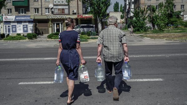 Люди несут воду на одной из улиц Николаева