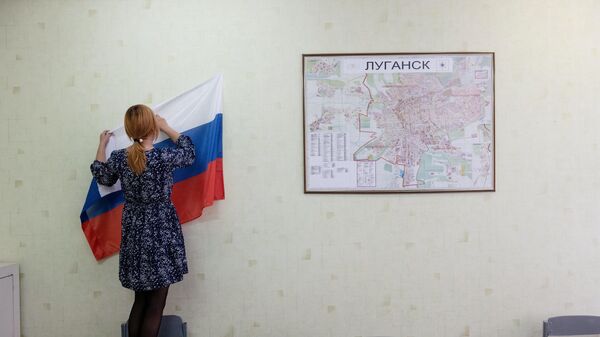 Сотрудница избирательной комиссии во время подготовки к референдуму о присоединении к России ЛНР на одном из избирательных участков в Луганске