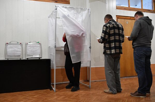 Люди голосуют на референдуме о присоединении Запорожской области к России на избирательном участке на Мелитопольском предприятии