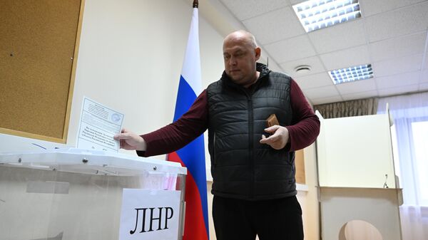 Мужчина голосует на референдуме о присоединении Луганской народной республики к России на избирательном участке в посольстве ДНР в Москве