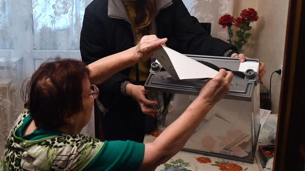 Женщина голосует надомно в Донецке на референдуме о вступлении Донецкой народной республики в состав РФ