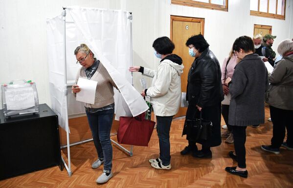 Люди голосуют на референдуме о присоединении Запорожской области к России на избирательном участке на Мелитопольском предприятии