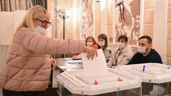 A woman votes at a ballot box at the Railway Workers' Culture House in Moscow, where voting takes place in the referendums on Russia's participation in the LPR and DPR.