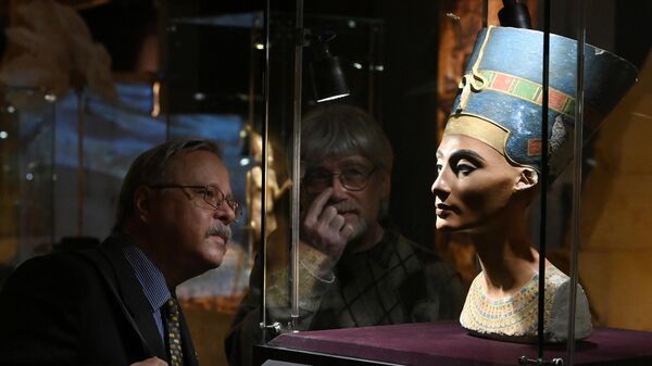 Мужчины около экспоната Бюст Нефертити на выставке Сокровища гробницы Тутанхамона