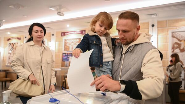Мужчина голосует на избирательном участке в Москве