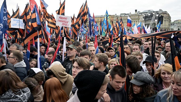 Люди перед началом митинга Своих не бросаем на Манежной площади в Москве