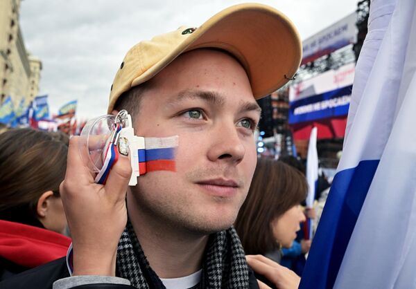Молодой человек перед началом митинга Своих не бросаем на Манежной площади в Москве