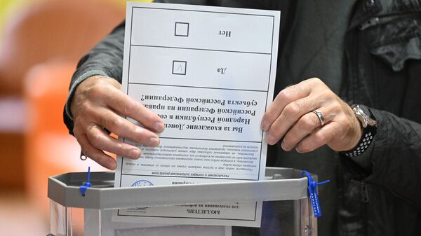 Мужчина голосует на референдуме о присоединении Донецкой народной республики и Луганской народной республики к России
