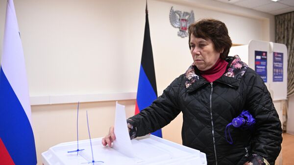 Женщина голосует на референдуме на избирательном участке в посольстве ДНР в Москве