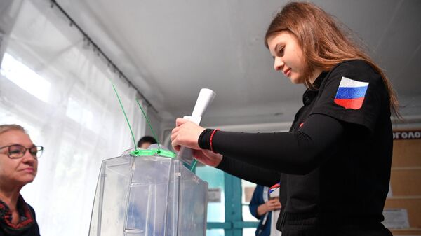 Девушка голосует на референдуме о присоединении Запорожской области к России на избирательном участке в Мелитополе