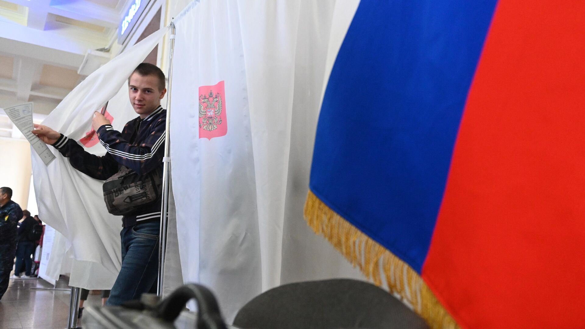 Молодой человек голосует на референдуме на избирательном участке - РИА Новости, 1920, 25.09.2022