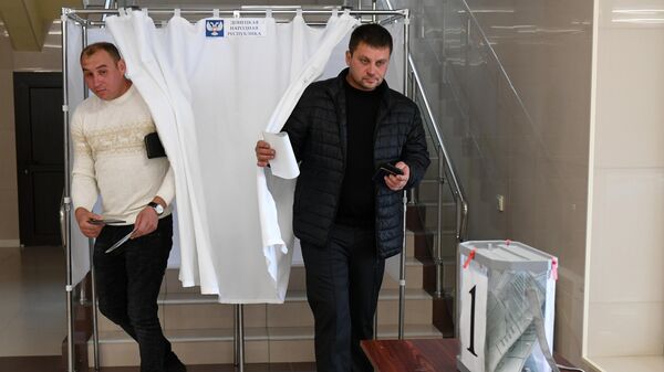 Мужчины голосуют на референдуме на избирательном участке