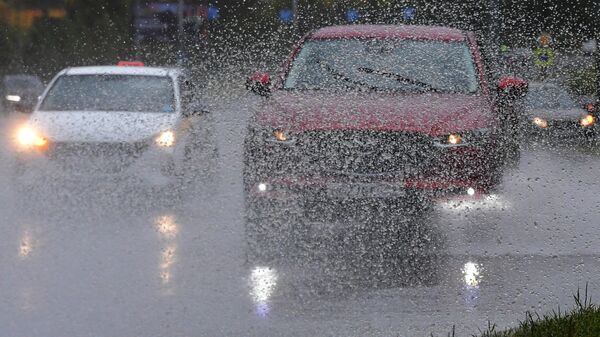 Автомобили во время дождя на одной из улиц в Москве