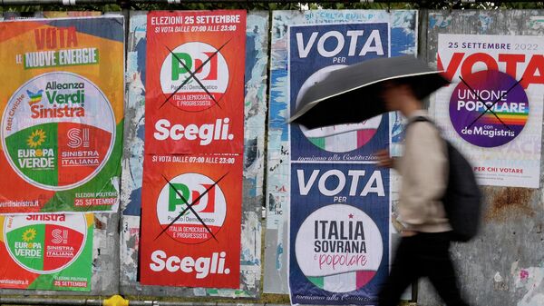 Мужчина проходит мимо предвыборных плакатов в Милане