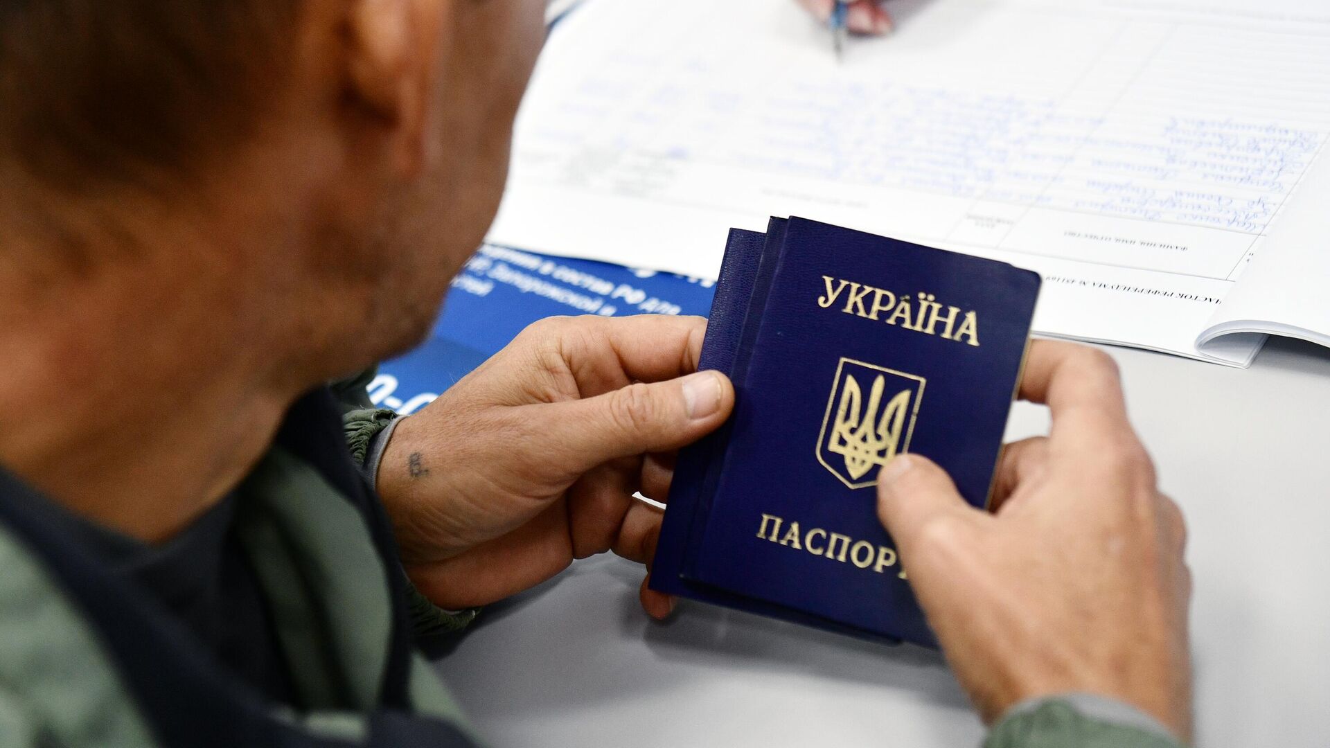 Мужчина с украинским паспортом проходит регистрацию для голосования на референдуме - РИА Новости, 1920, 25.09.2022