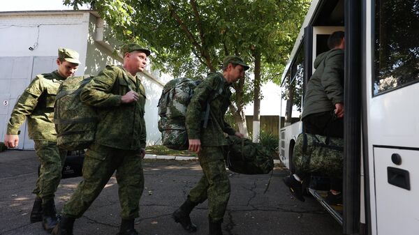 Мужчины, призванные на воинскую службу в ходе частичной мобилизации, садятся в автобус у военного комиссариата Краснодара