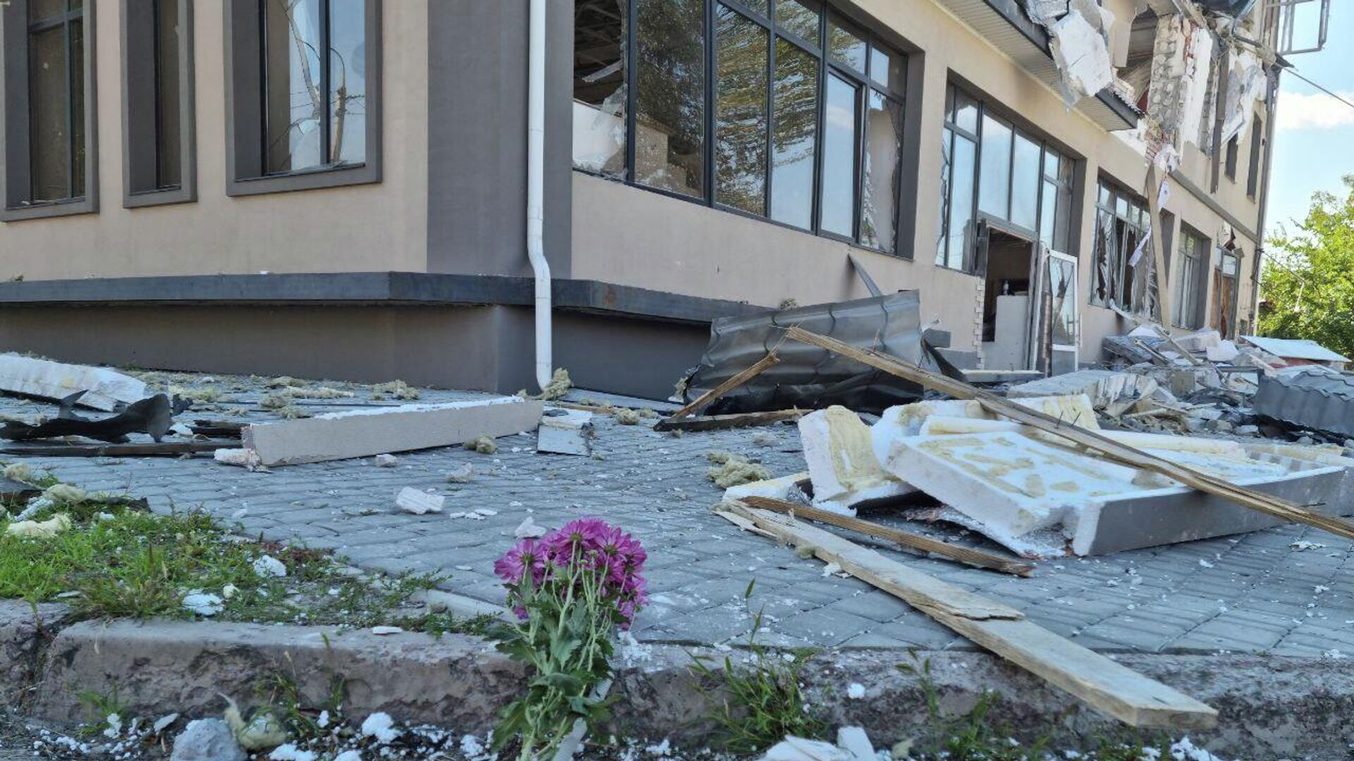 Цветы у разрушенного в результате обстрела ВСУ здания гостиницы Play в Херсоне - РИА Новости, 1920, 25.09.2022