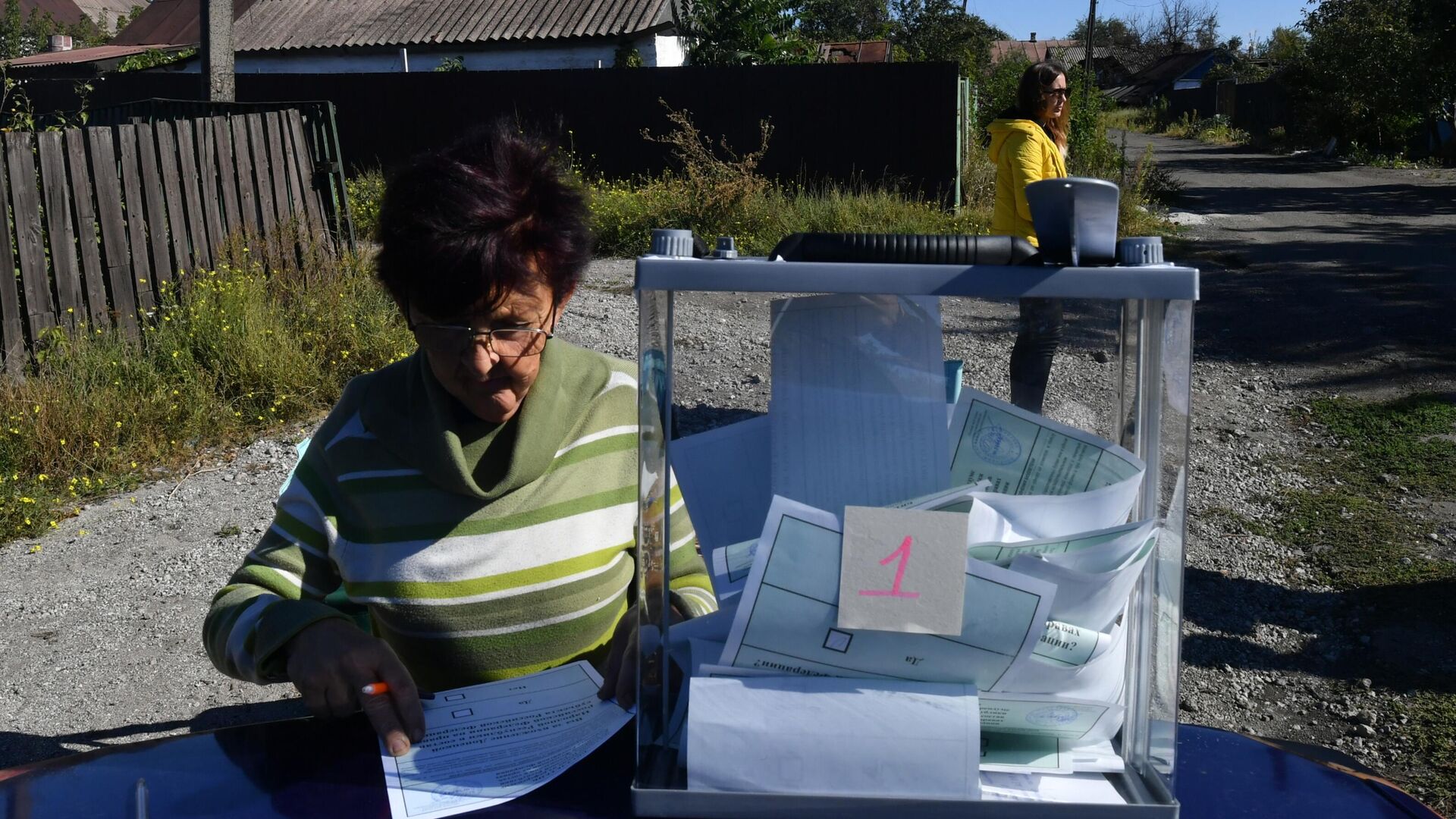 Женщина голосует на выездном избирательном участке в Мариуполе - РИА Новости, 1920, 27.09.2022