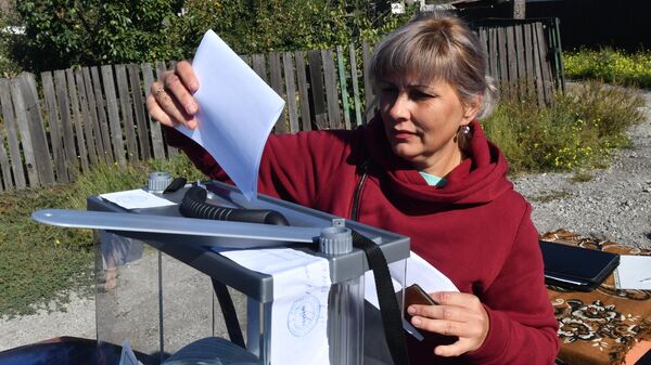 Женщина голосует на выездном избирательном участке в Мариуполе